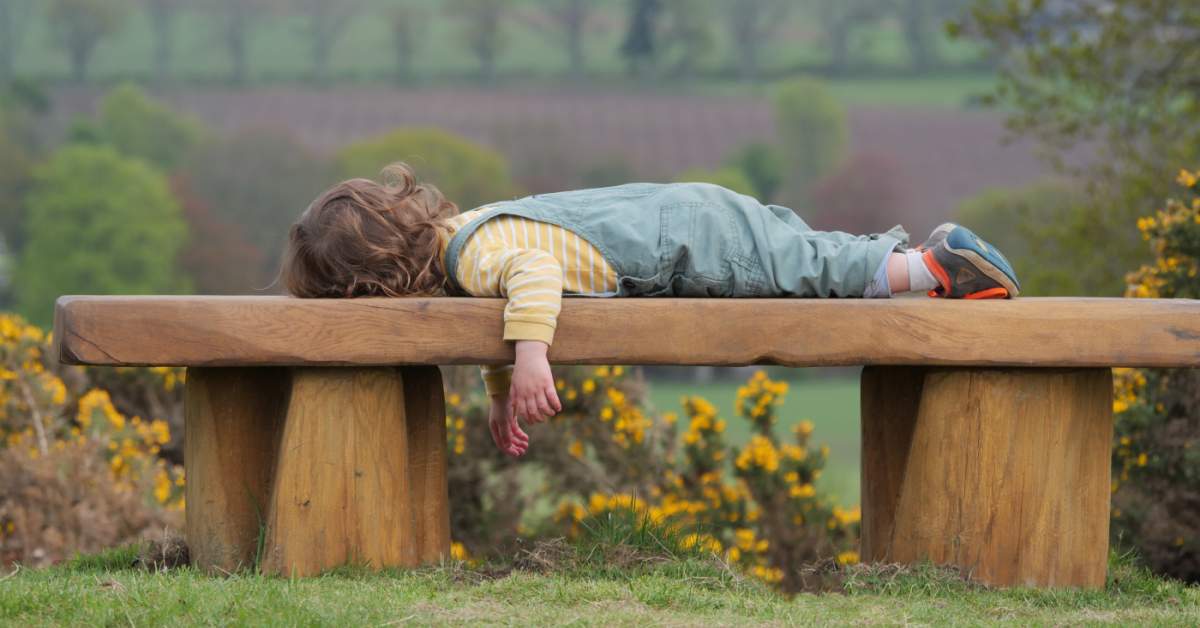 Child,Lying,Down,On,A,Countryside,Bench