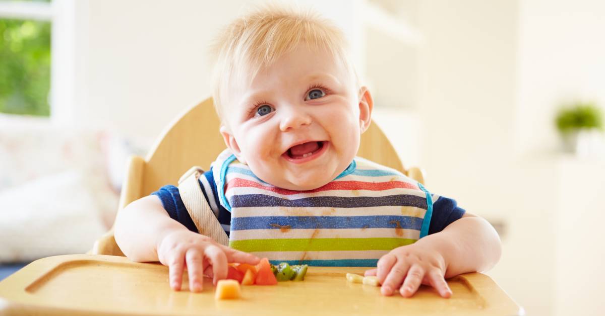 Baby,Boy,Eating,Fruit,In,High,Chair