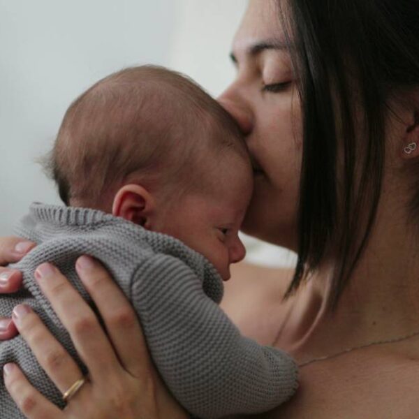 Candid,Mother,Holding,Newborn,Baby,In,Bed,Showing,Love,Care